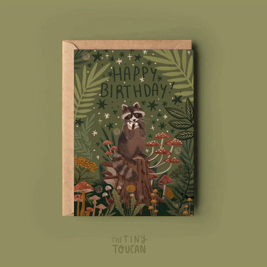 Birthday card with raccoon illustration and 'Happy Birthday!' text on a green background